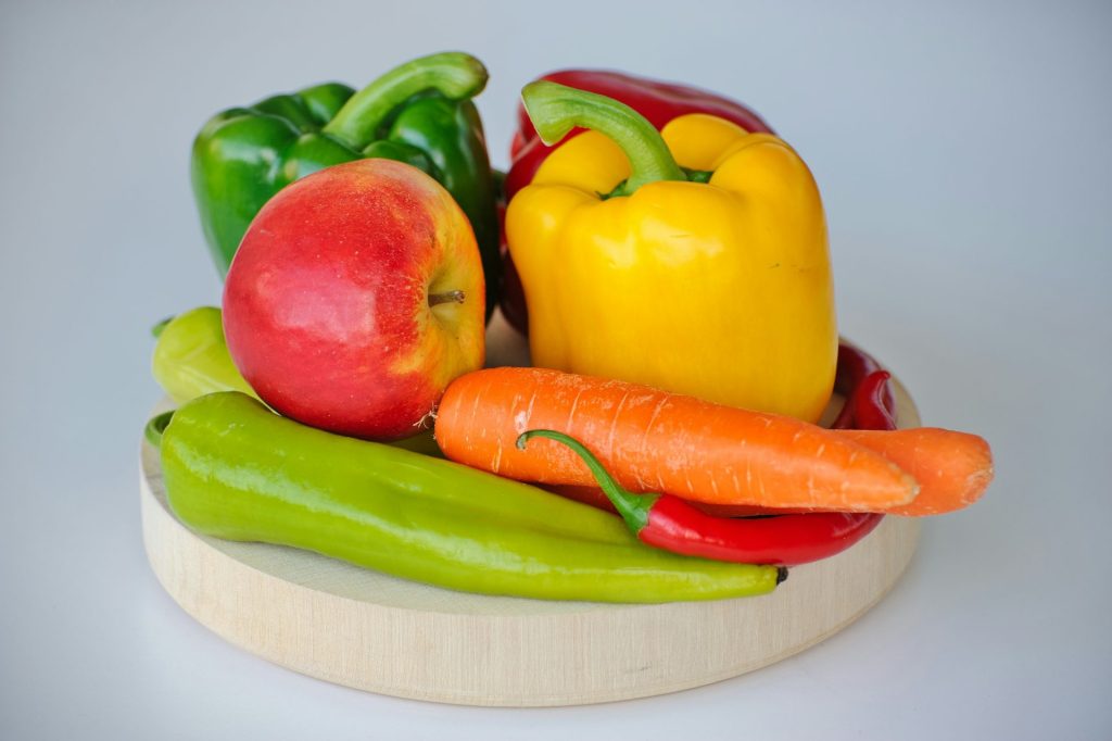 red and green bell pepper and red apple on white plate