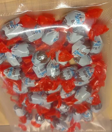 Kinder Schoko-Bons Bonbons enrobés de chocolat, emballés individuellement avec un papier rouge.